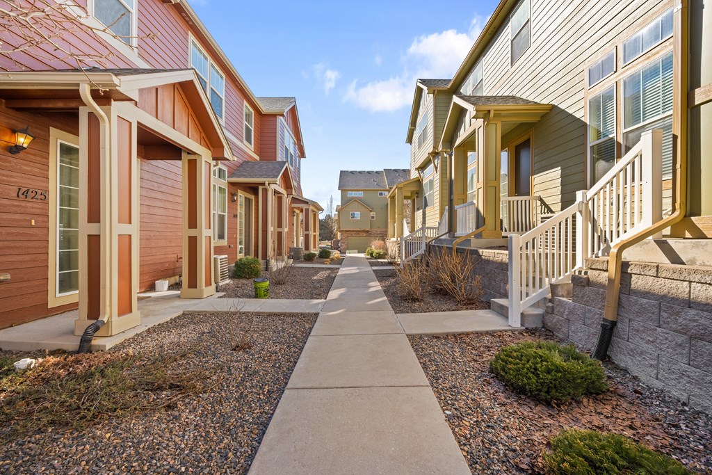 A row of houses with a sidewalk in between.