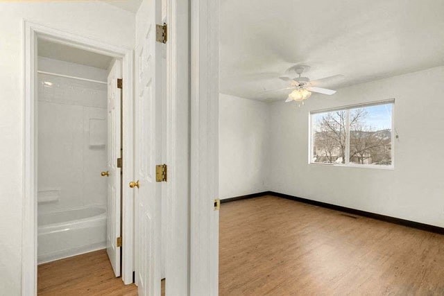 an empty room with a ceiling fan and a window
