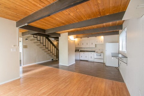 A kitchen with white cabinets and a wooden floor.