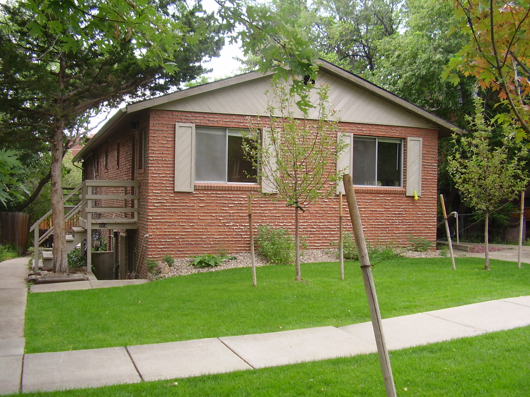 A small house with a brown brick exterior and a white window.