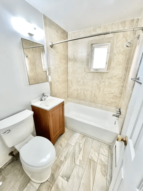 A bathroom with a toilet, sink, and bathtub.
