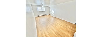 A room with wooden flooring and a window.