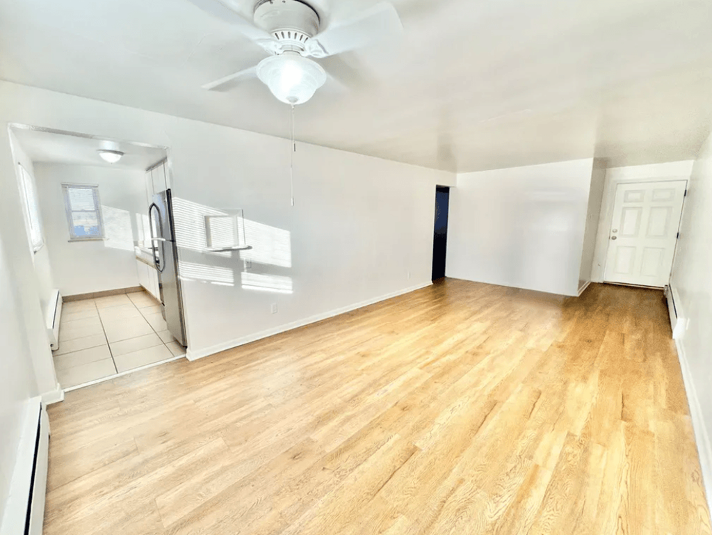 A room with wooden flooring and a ceiling fan.