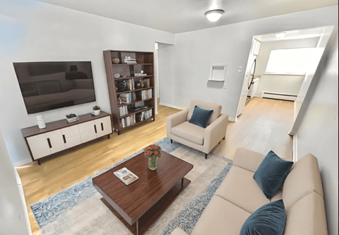 A living room with a couch, a coffee table, and a television.