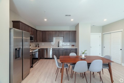 A modern kitchen with a dining table and chairs.