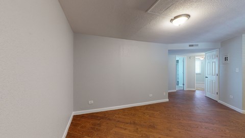 A room with wooden floors and white walls.