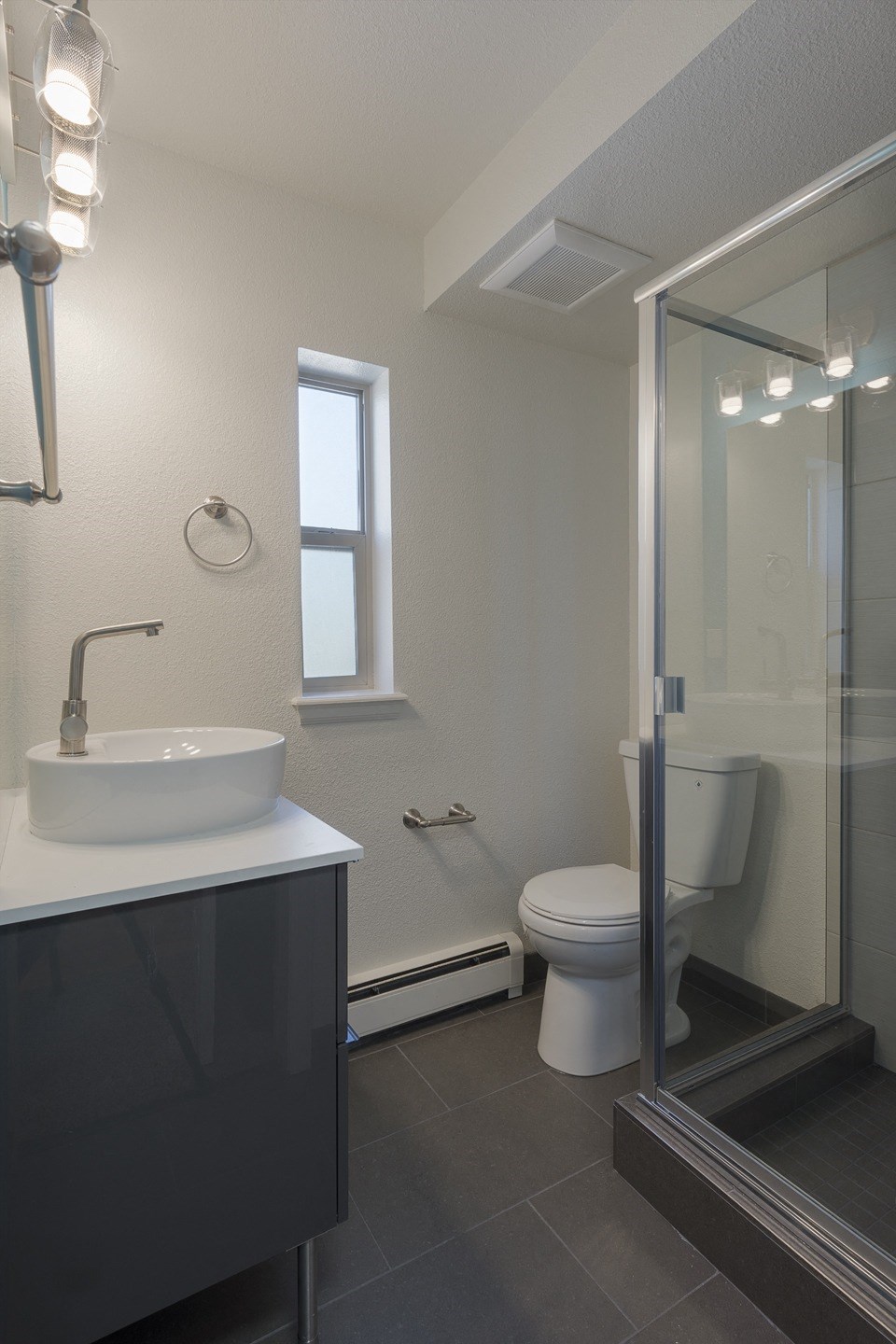 a bathroom with a toilet and a sink and a shower