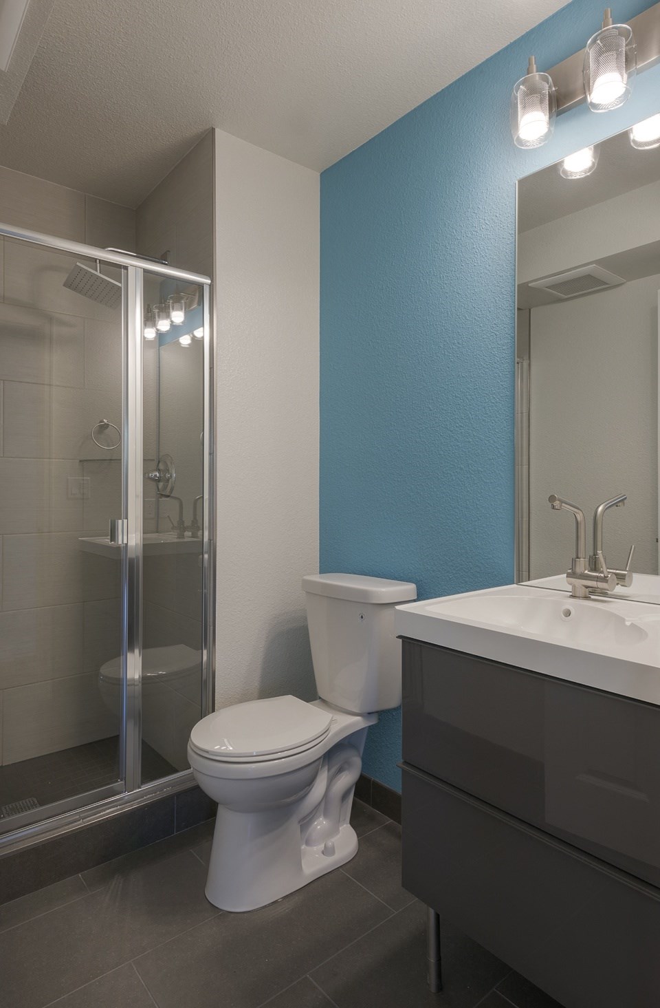 a bathroom with a toilet and a sink and a shower