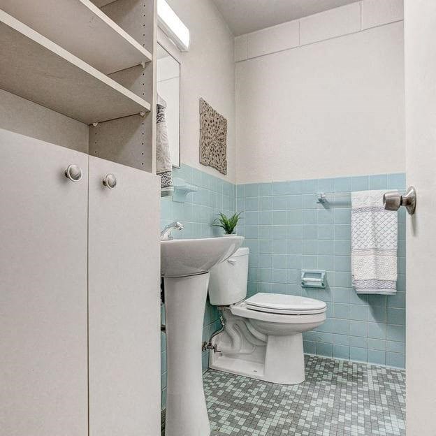 a white bathroom with a toilet and a sink