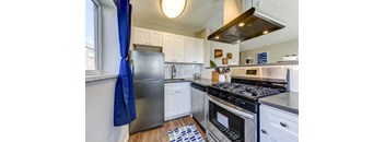 A kitchen with a stainless steel refrigerator and oven.