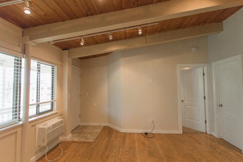 a living room with white walls and a wooden ceiling