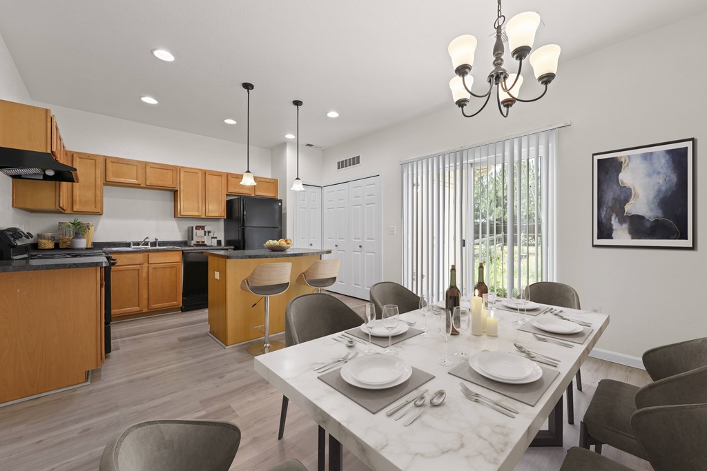 A modern kitchen with a dining table set for two.
