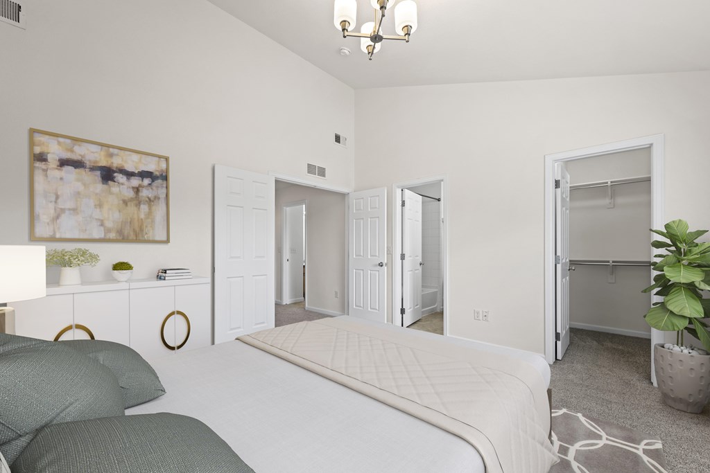 A bedroom with a bed, a couch, and a painting on the wall.