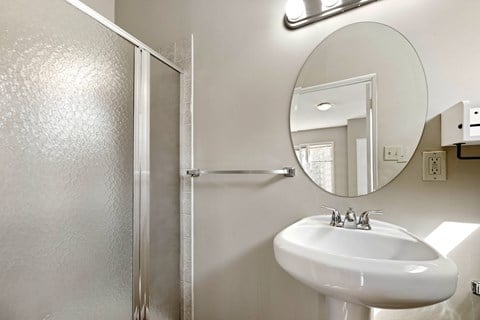 A bathroom with a white sink and a mirror.