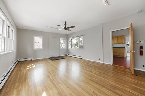 A room with wooden floors and a ceiling fan.