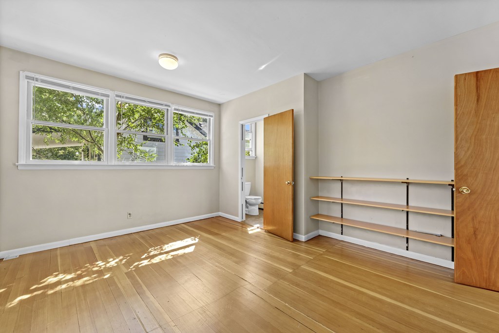 A room with wooden floors and a large window.