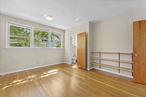 A room with wooden floors and a large window.