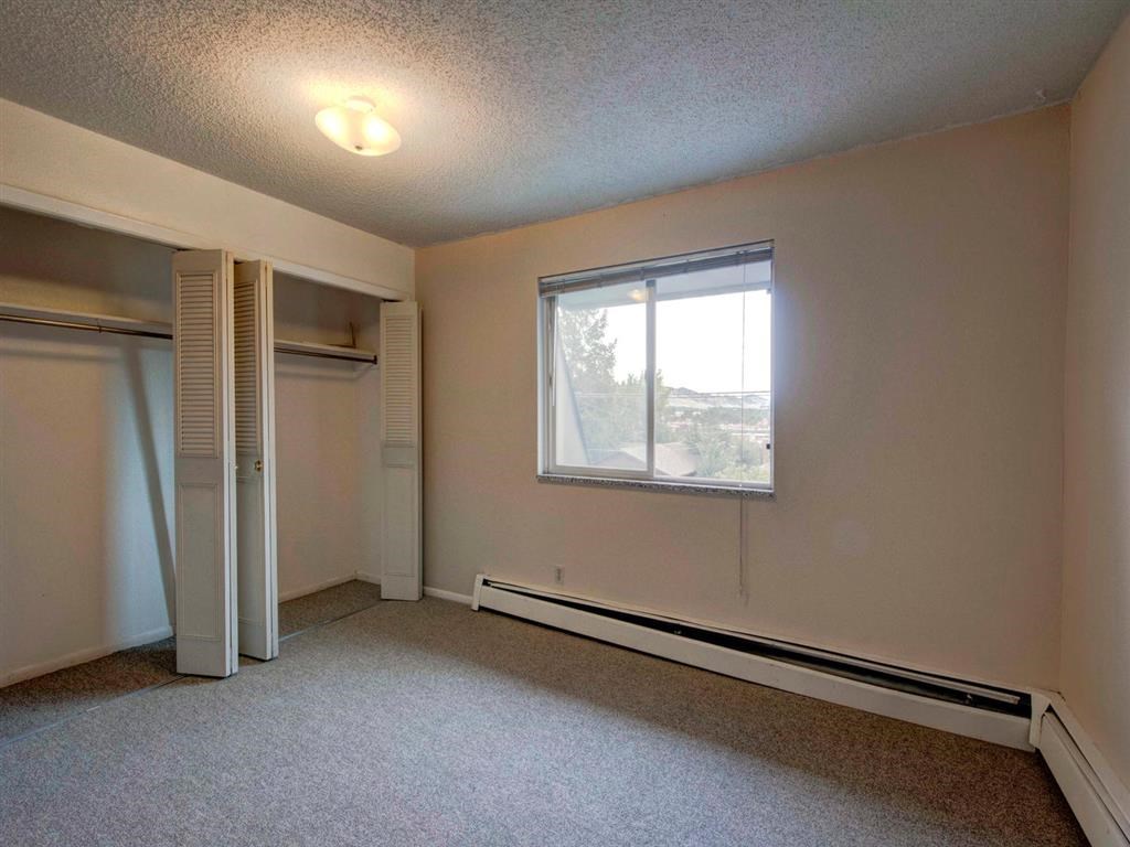 an empty living room with a window and a closet