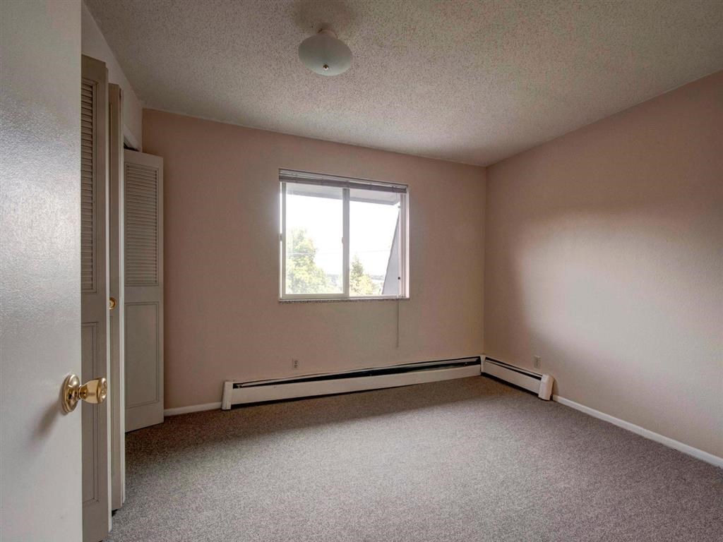 an empty room with pink walls and a window