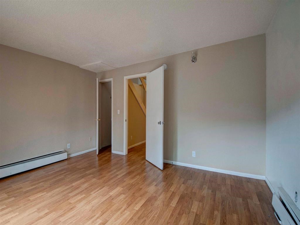 a living room with a hard wood floor and a door to a staircase