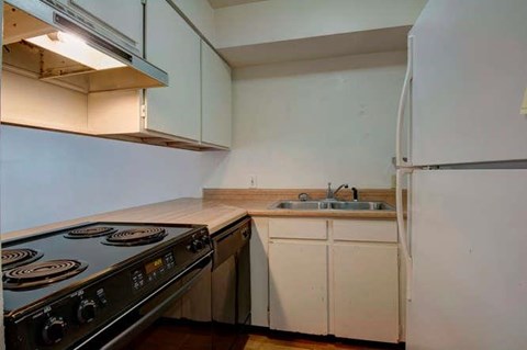 an empty kitchen with a stove and a sink