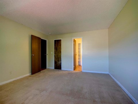 an empty living room with white walls and carpet