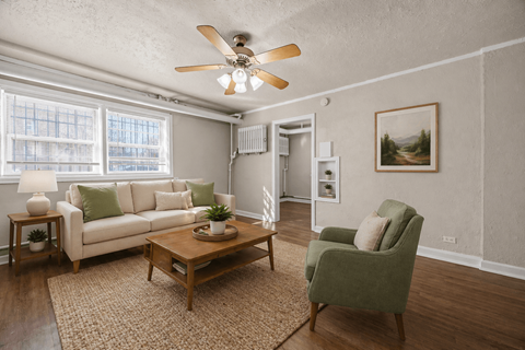 A living room with a white couch, green armchair, and a coffee table.