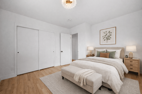 A bedroom with a large bed and a bench in front of it.