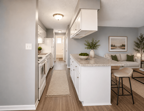A kitchen with white cabinets and a white island with a bowl on top.