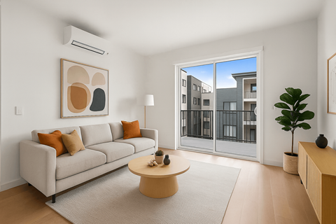 A living room with a grey couch, a coffee table, and a painting on the wall.