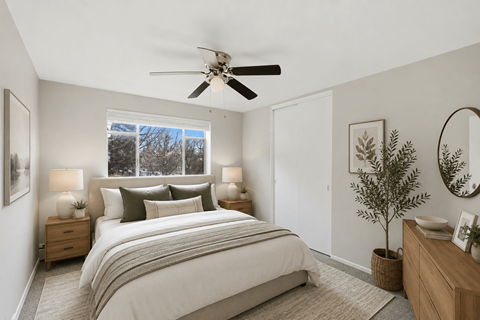A bedroom with a large bed and a ceiling fan.