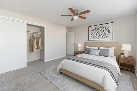 A bedroom with a large bed and a ceiling fan.