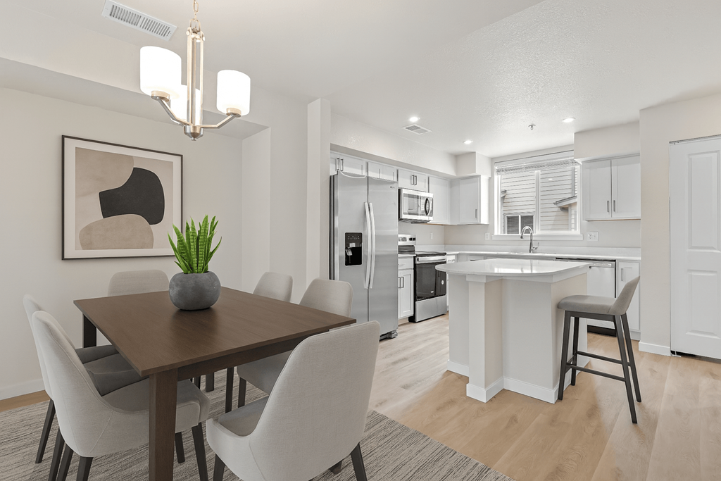 Modern dining room with a wooden table and white chairs at The Townhomes at Pine Drive, Parker, CO, 80138