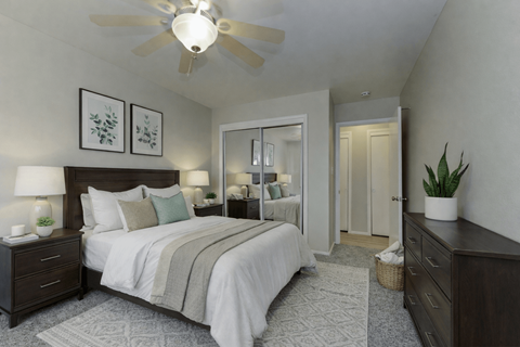 A bedroom with a large bed and a ceiling fan.