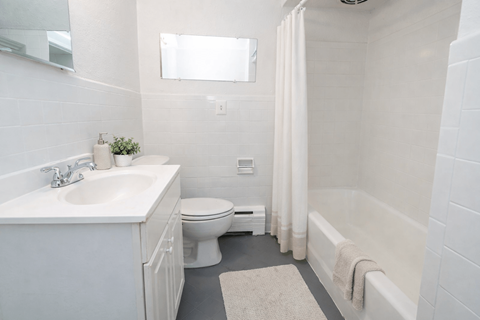 A white bathroom with a toilet, sink, and bathtub.
