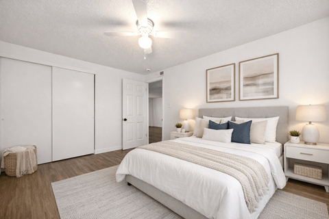 A bedroom with a large bed and two nightstands.