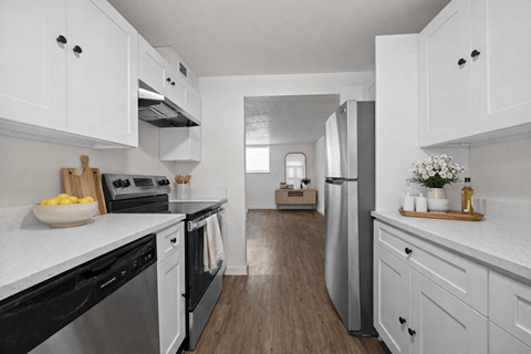 A modern kitchen with white cabinets and stainless steel appliances.