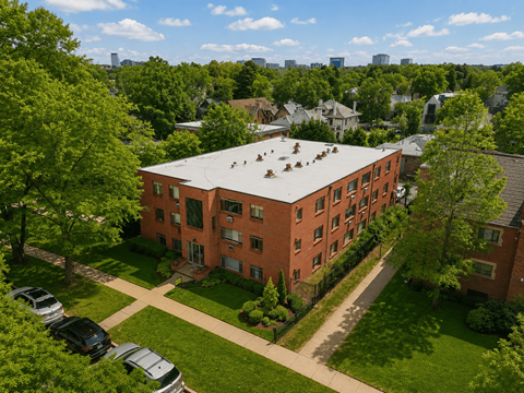 A red brick building with a green lawn in front.