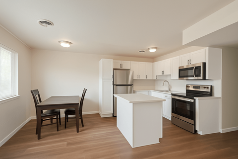 A kitchen with a table and chairs in it.