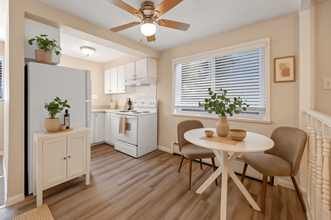 A kitchen with a table and chairs.