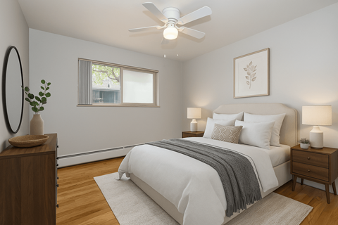 A bedroom with a large bed, a ceiling fan, and a window with a view of a building outside.