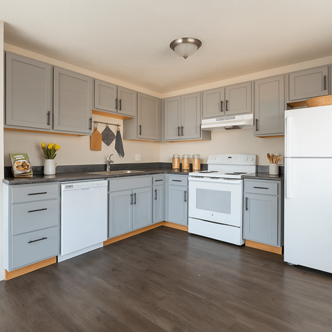 A kitchen with white appliances and grey cabinets.