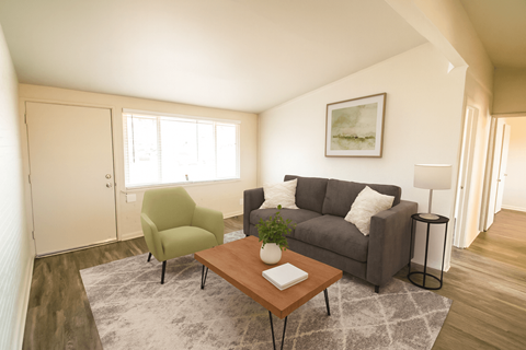 A living room with a green chair and a grey couch.