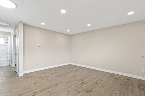 a living room with white walls and wood floors