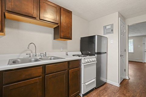 A kitchen with a black refrigerator and white countertops.