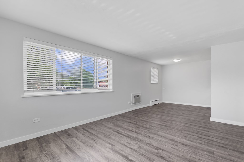 A room with a window and wooden flooring.