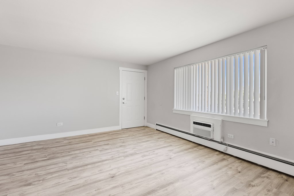 A room with a white door and a window with blinds.