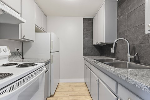 A kitchen with a white stove top oven and a white refrigerator.