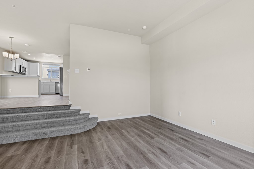Spacious room with wooden flooring and a staircase at The Townhomes at Pine Drive, Parker, CO, 80138