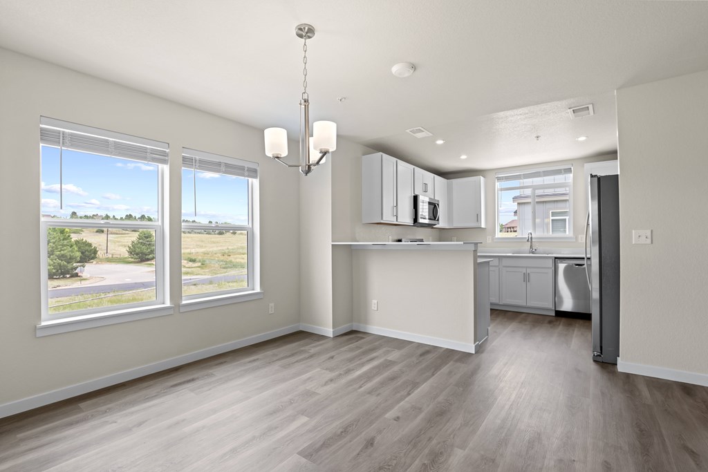 Kitchen with white cabinets and a wooden floor at The Townhomes at Pine Drive, Parker, 80138
